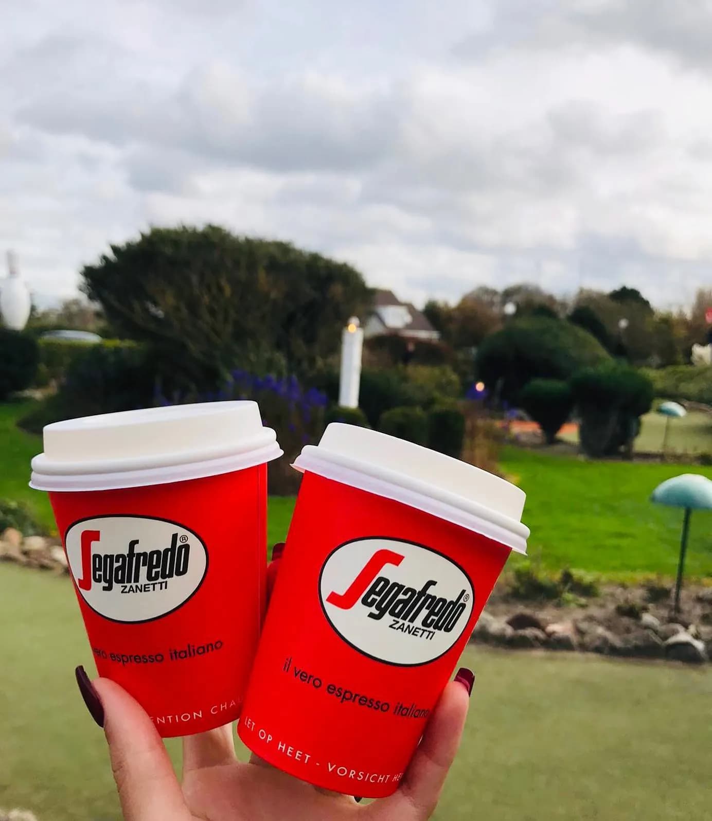 Twee rode koffiebekers boven de baan