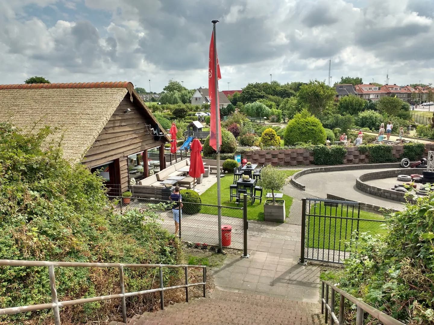 Clubhuis met rieten dak en trap naar het terras