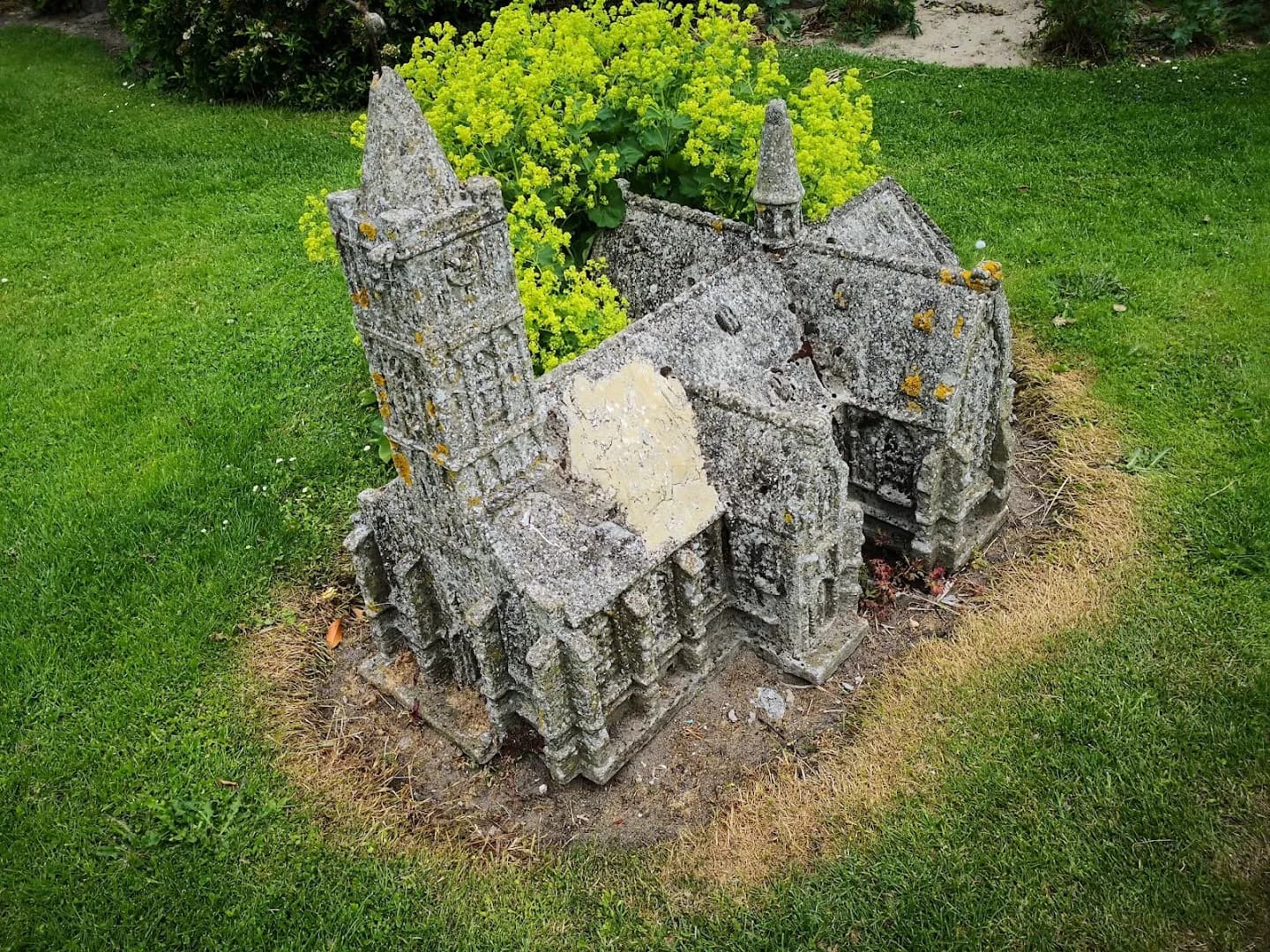 Miniatuurkerkje met planten op de baan
