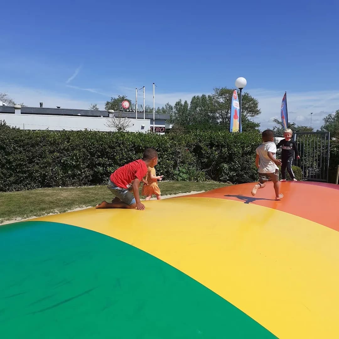 Kinderen spelen op de regenboogtrampoline
