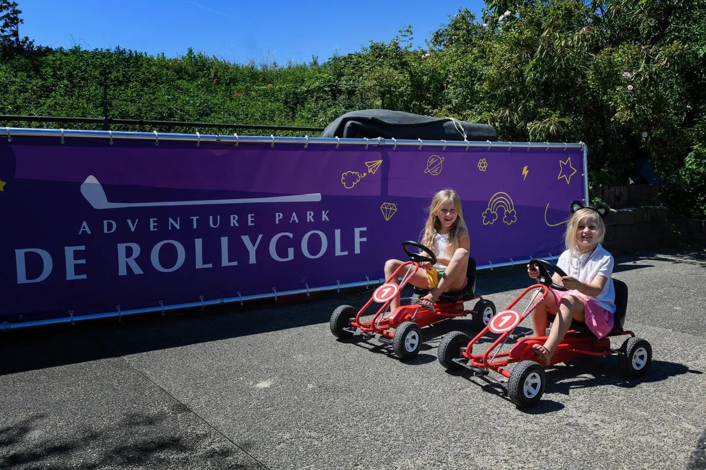 Twee meisjes in minicars voor het Rollygolf-doek