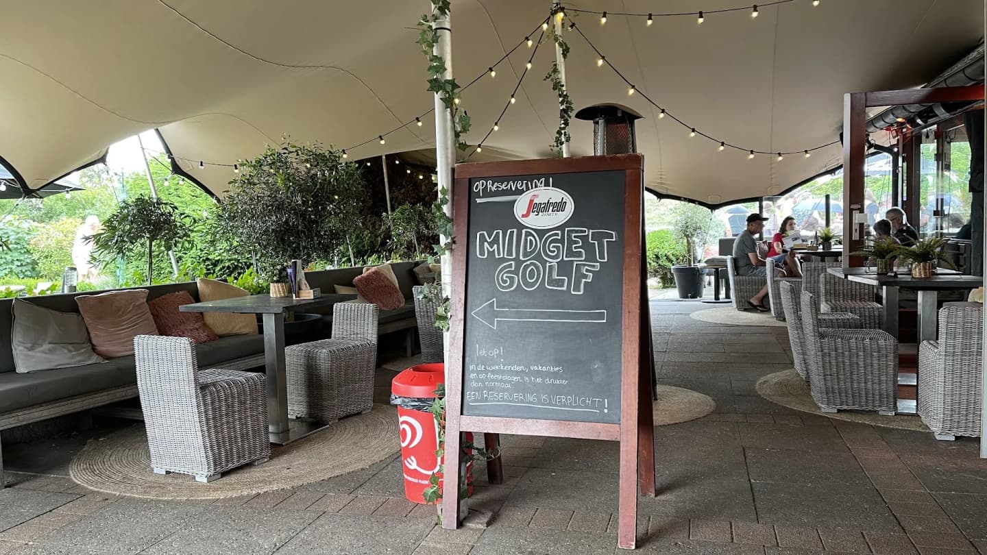 Overdekt terras met loungebanken en lichtjes